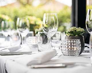Une table dressée avec des verres et une décoration florale.