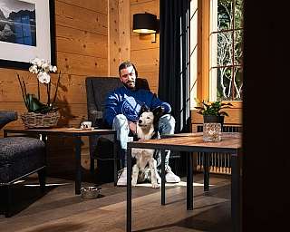 Homme assis avec son chien dans le hall