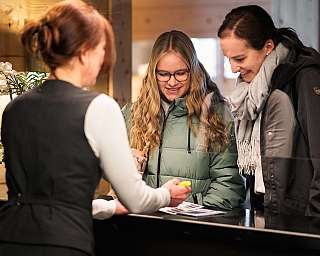 Deux invités discutent avec une réceptionniste.