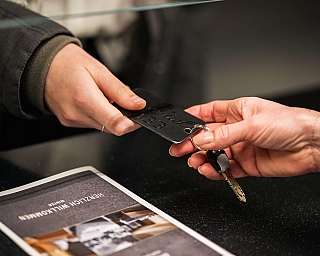 Une personne remet une clé et un numéro de chambre à un client.