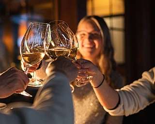 Several people are toasting with wine glasses in a festive setting.