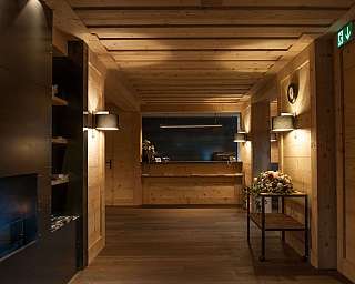 A stylish reception area with wooden paneling and a flower arrangement.