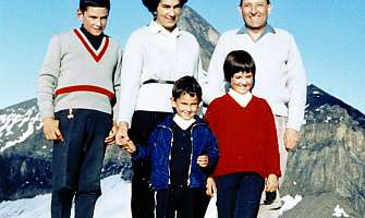 Une famille pose devant un paysage montagneux.