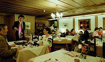 Un serveur sert un plat flambé dans un restaurant confortable.