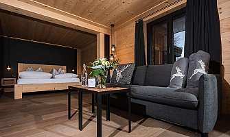 A modern room with a sofa, table, and wooden bed.