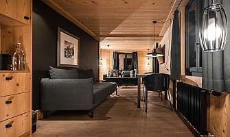 Modern living room with sofa, table and wooden cladding.