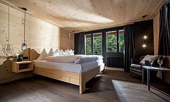 Cozy bedroom with wooden decor and large windows.