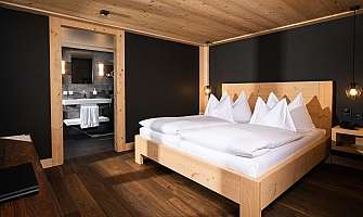 Bright bedroom with wooden decor and adjoining bathroom.