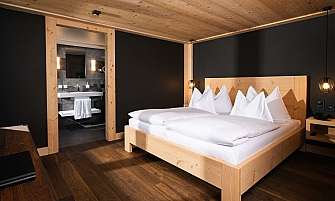Bright bedroom with wooden decor and adjoining bathroom.