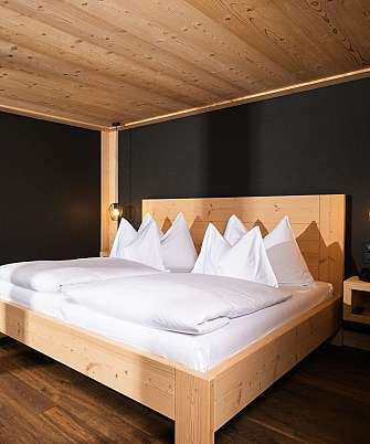 Bright bedroom with wooden decor and adjoining bathroom.