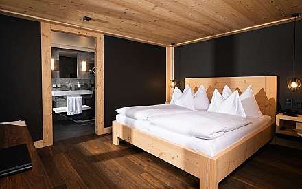 Bright bedroom with wooden decor and adjoining bathroom.