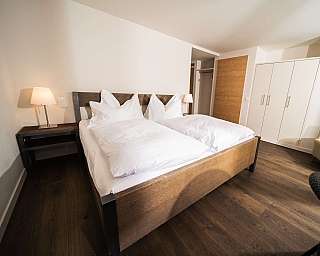 Cozy bedroom with wooden floor and modern furniture.