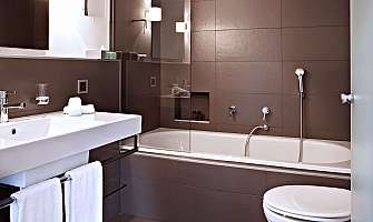 Elegant bathroom with sink, bathtub and towels.