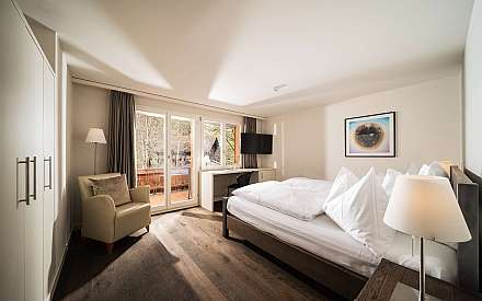 Cozy hotel room with double bed and balcony view.