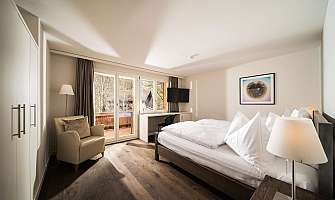 Cozy hotel room with double bed and balcony view.