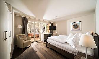 Cozy hotel room with double bed and balcony view.