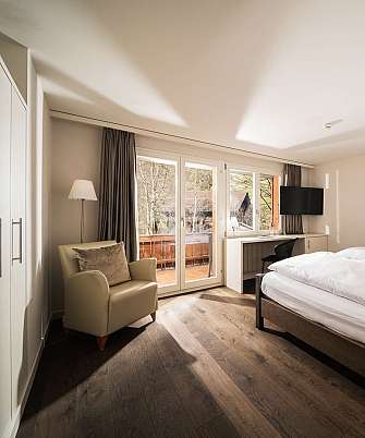 Cozy hotel room with double bed and balcony view.