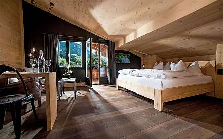 Bright bedroom with wooden decor and a view of the mountains.