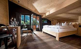 Bright bedroom with wooden decor and a view of the mountains.