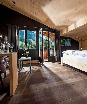 Bright bedroom with wooden decor and a view of the mountains.