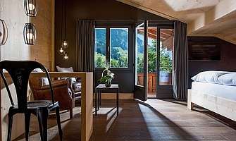 Bright hotel room with balcony and mountain view.